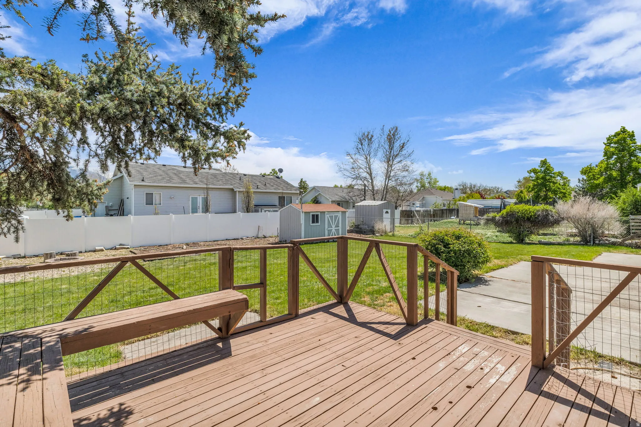Deck featuring a shed, a residential view, and a fenced backyard