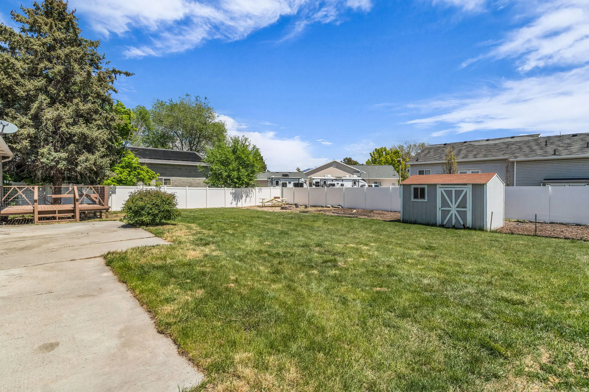Fenced backyard featuring a storage shed