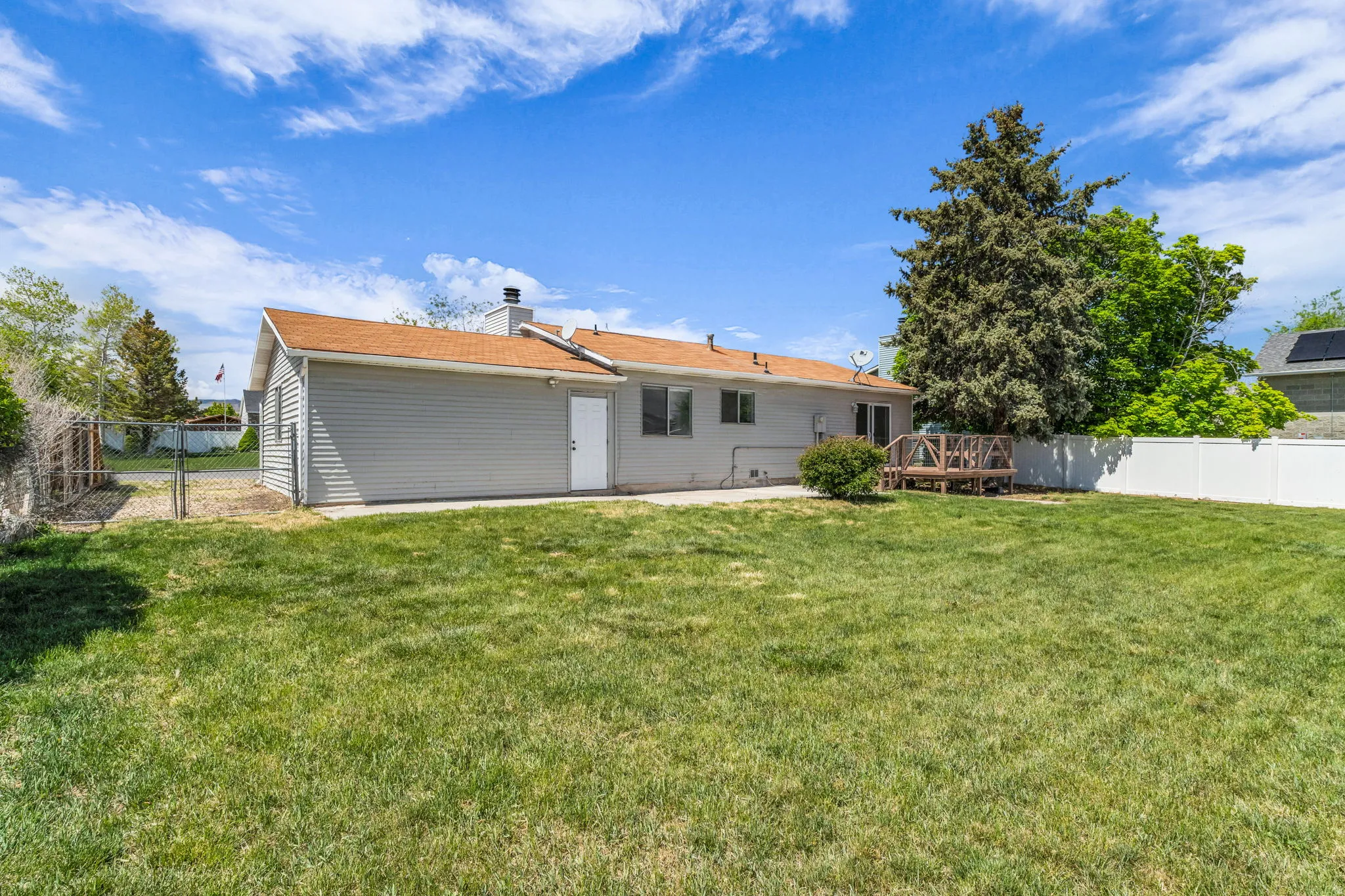 Back of property featuring a fenced backyard, a chimney, and a gate