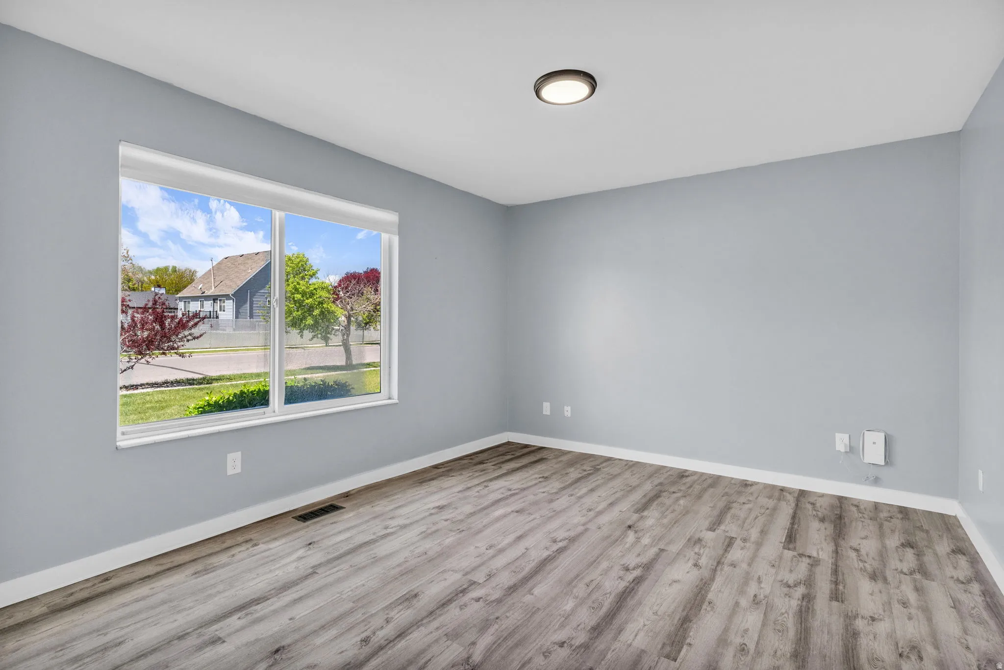 Empty bedroom with light wood-type flooring and baseboards