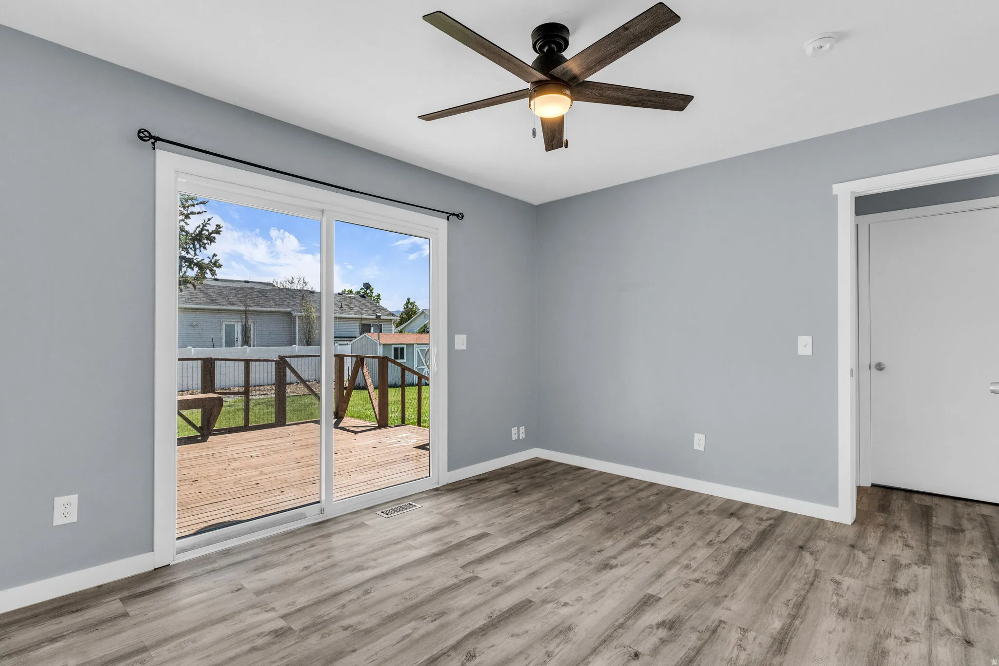 Empty primary bedroom featuring ceiling fan and light wood-style floors
