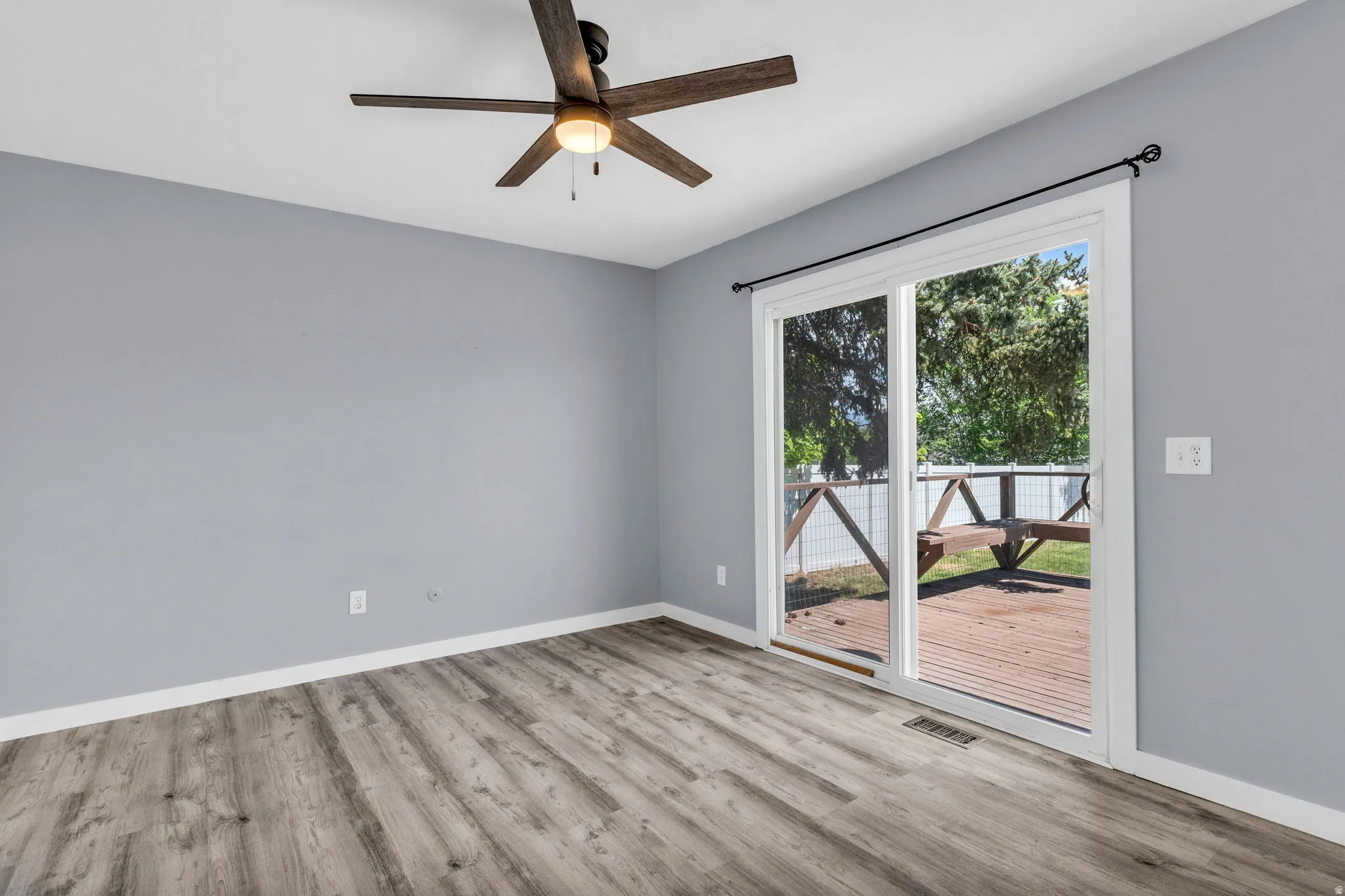 Unfurnished primary bedroom featuring light wood-style flooring and ceiling fan