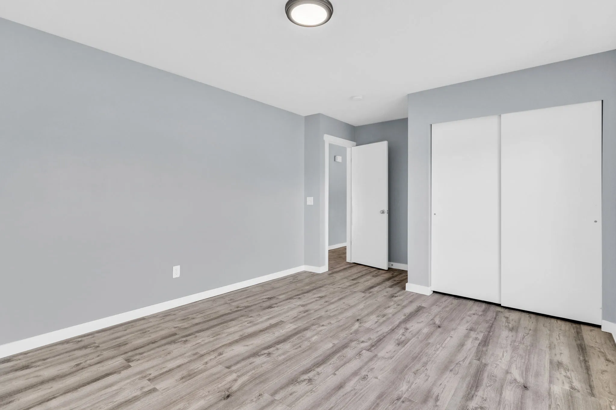 Unfurnished bedroom with light wood finished floors and a closet