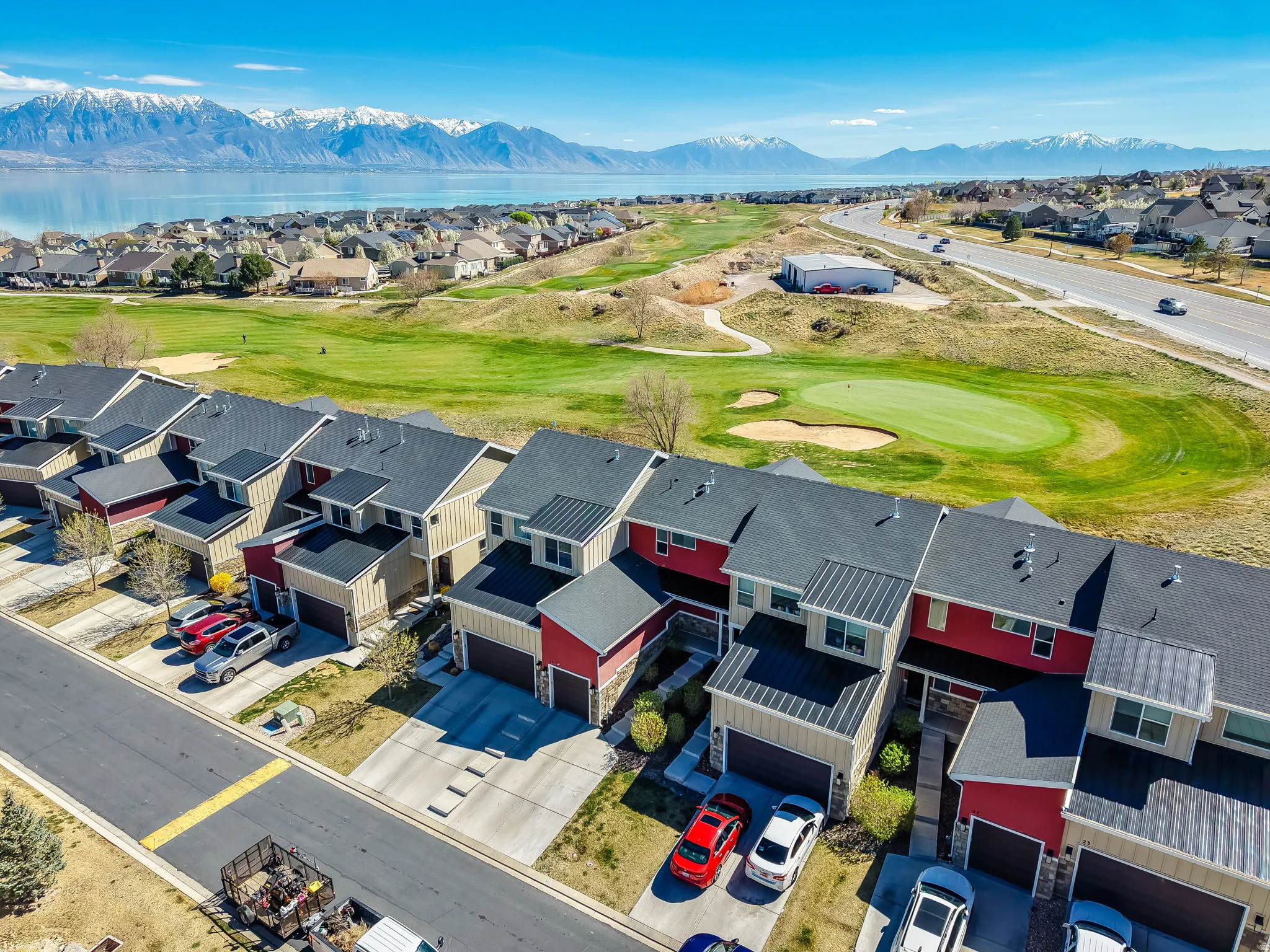 Aerial perspective of suburban area with a mountain backdrop and a golf club