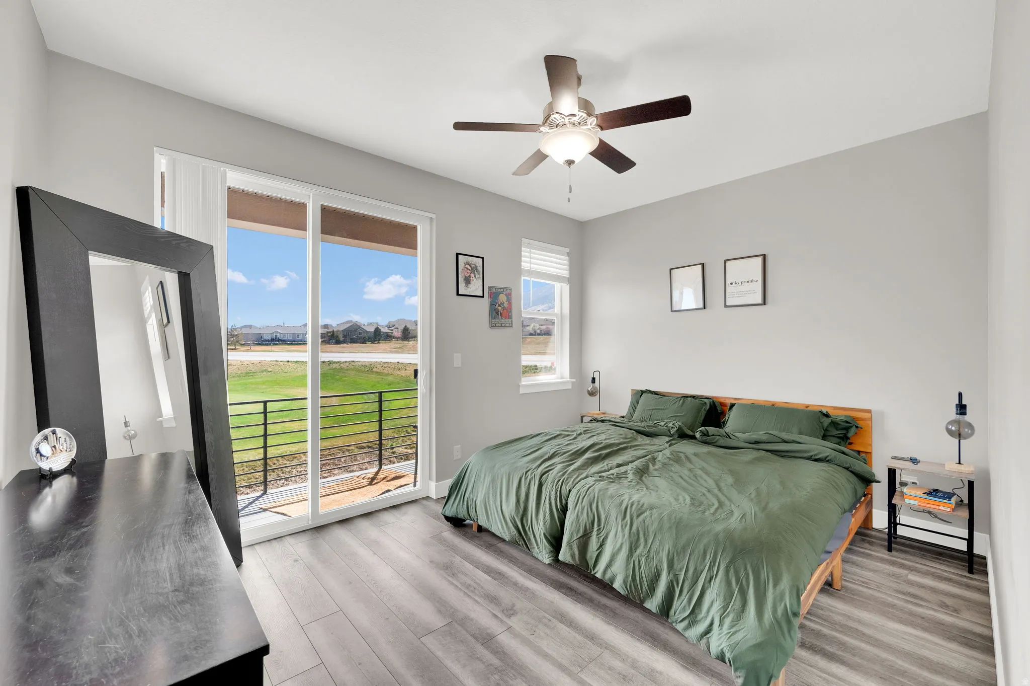 Bedroom with light wood finished floors, access to outside, a ceiling fan, and golf course view