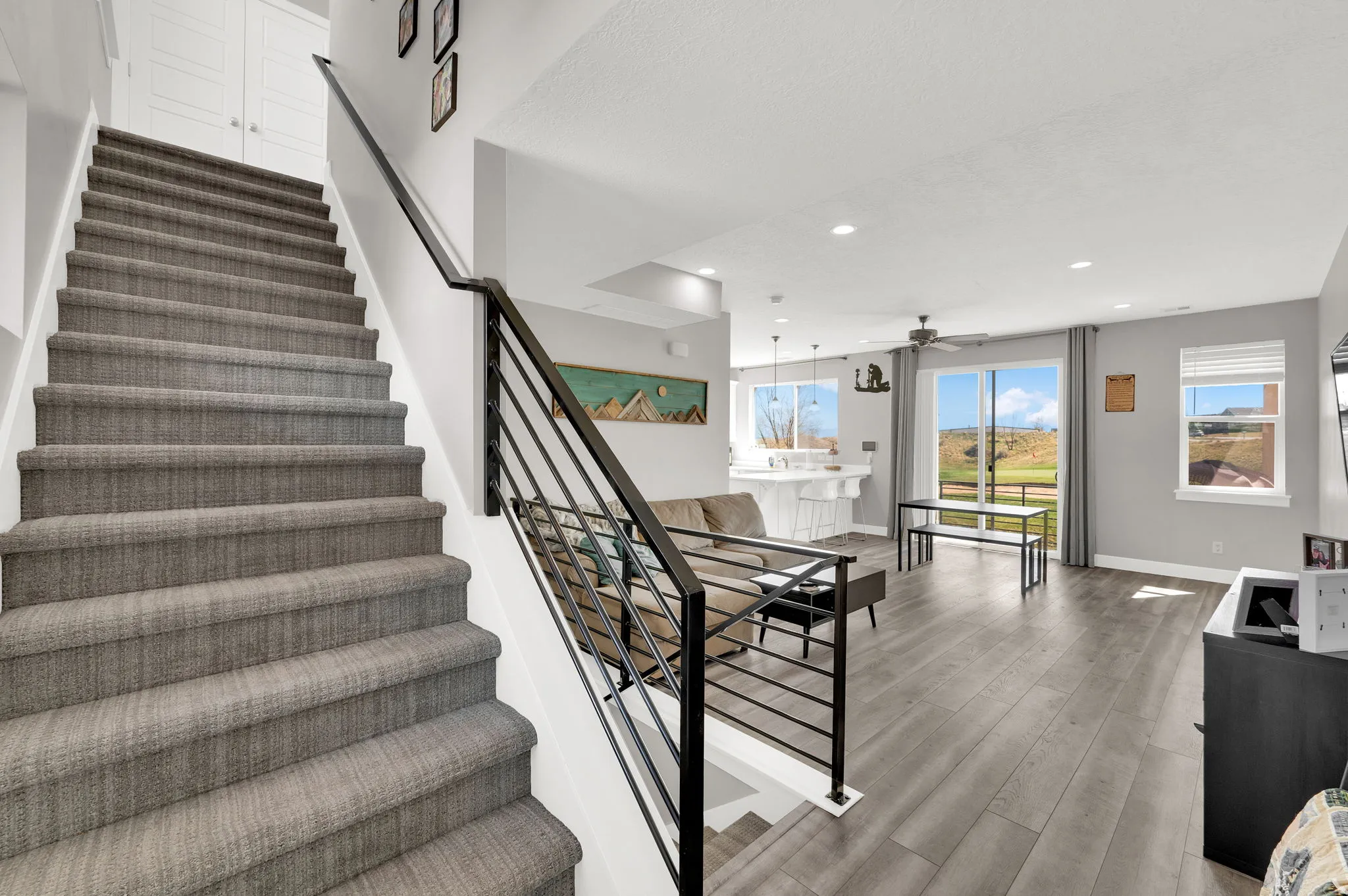Staircase with wood finished floors, a ceiling fan, and recessed lighting
