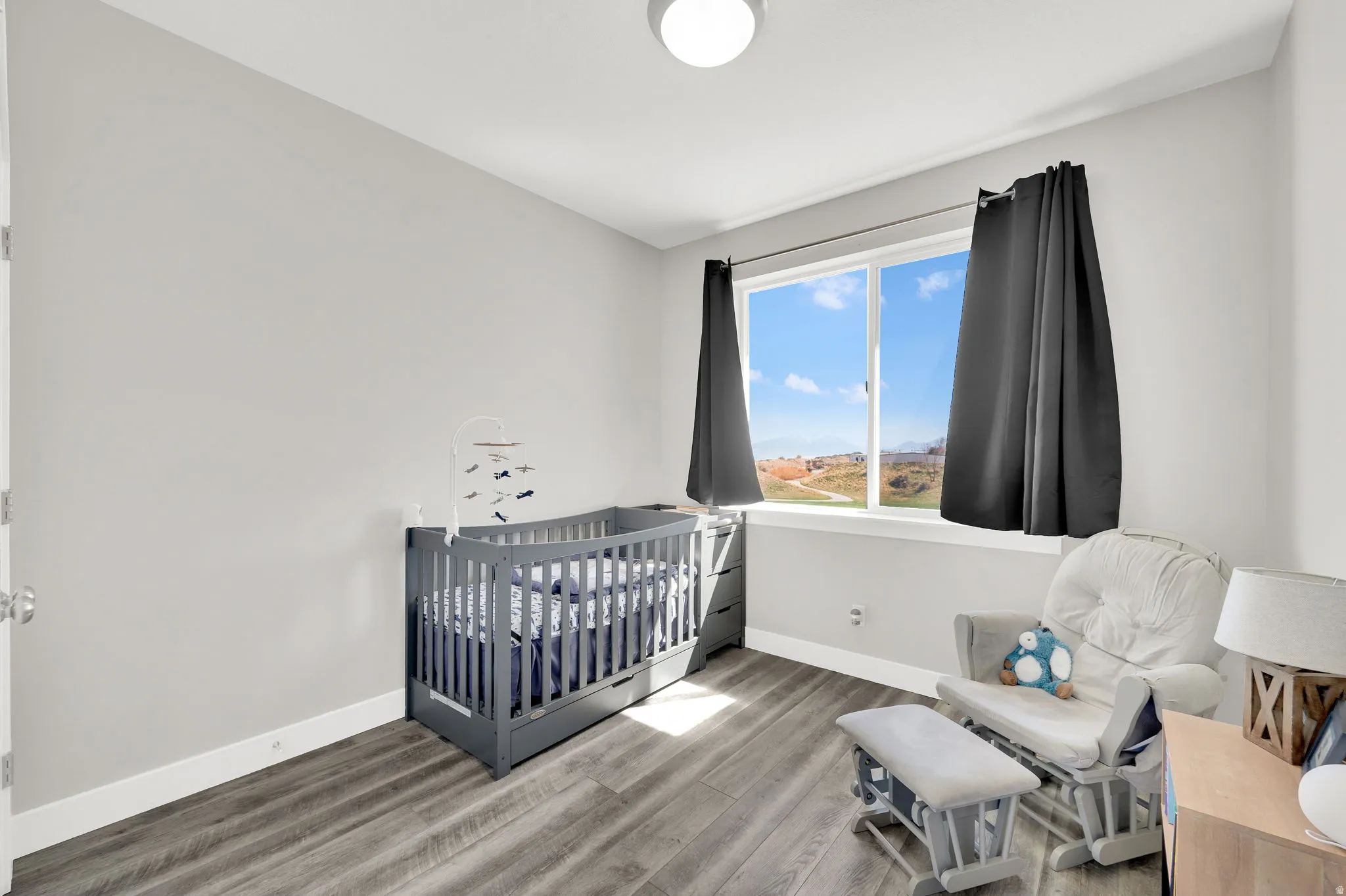 Bedroom with light wood-type flooring and a nursery area