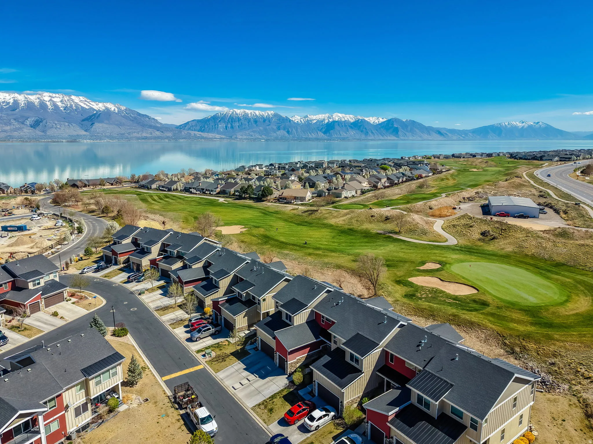 Aerial view of residential area with a golf club and a water and mountain view