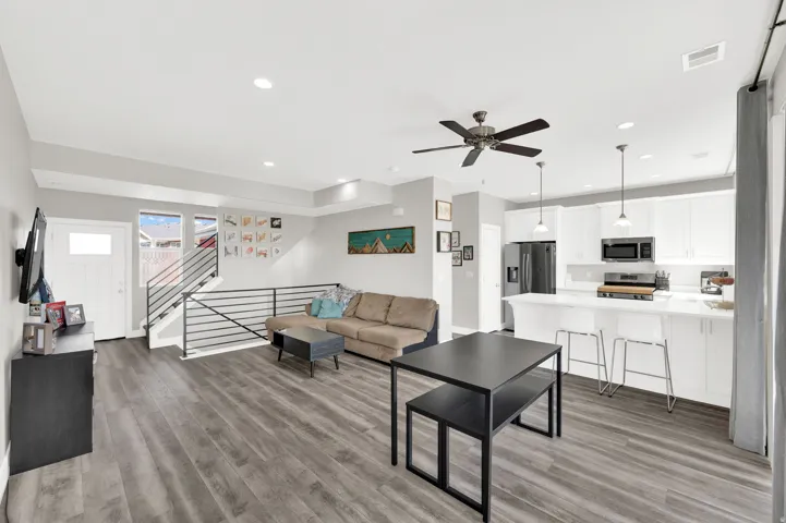 Living room featuring light wood-style flooring, ceiling fan, and recessed lighting