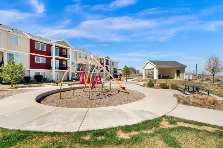 Communal playground with a patio area and a residential view