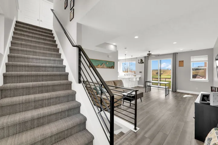 Staircase with wood finished floors, a ceiling fan, and recessed lighting