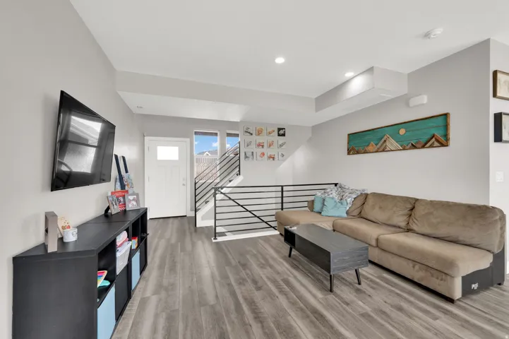 Living area with light wood-type flooring and stairs