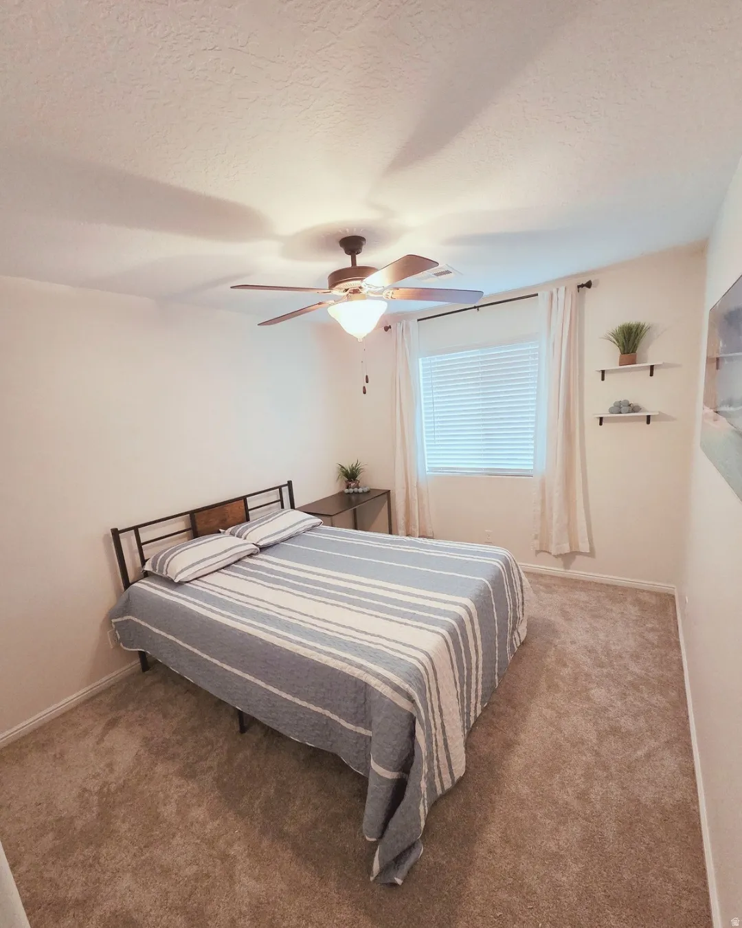 Bedroom featuring carpet floors, a textured ceiling, and a ceiling fan