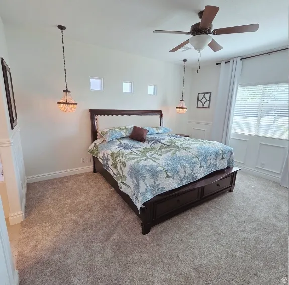 Bedroom featuring a ceiling fan and light carpet