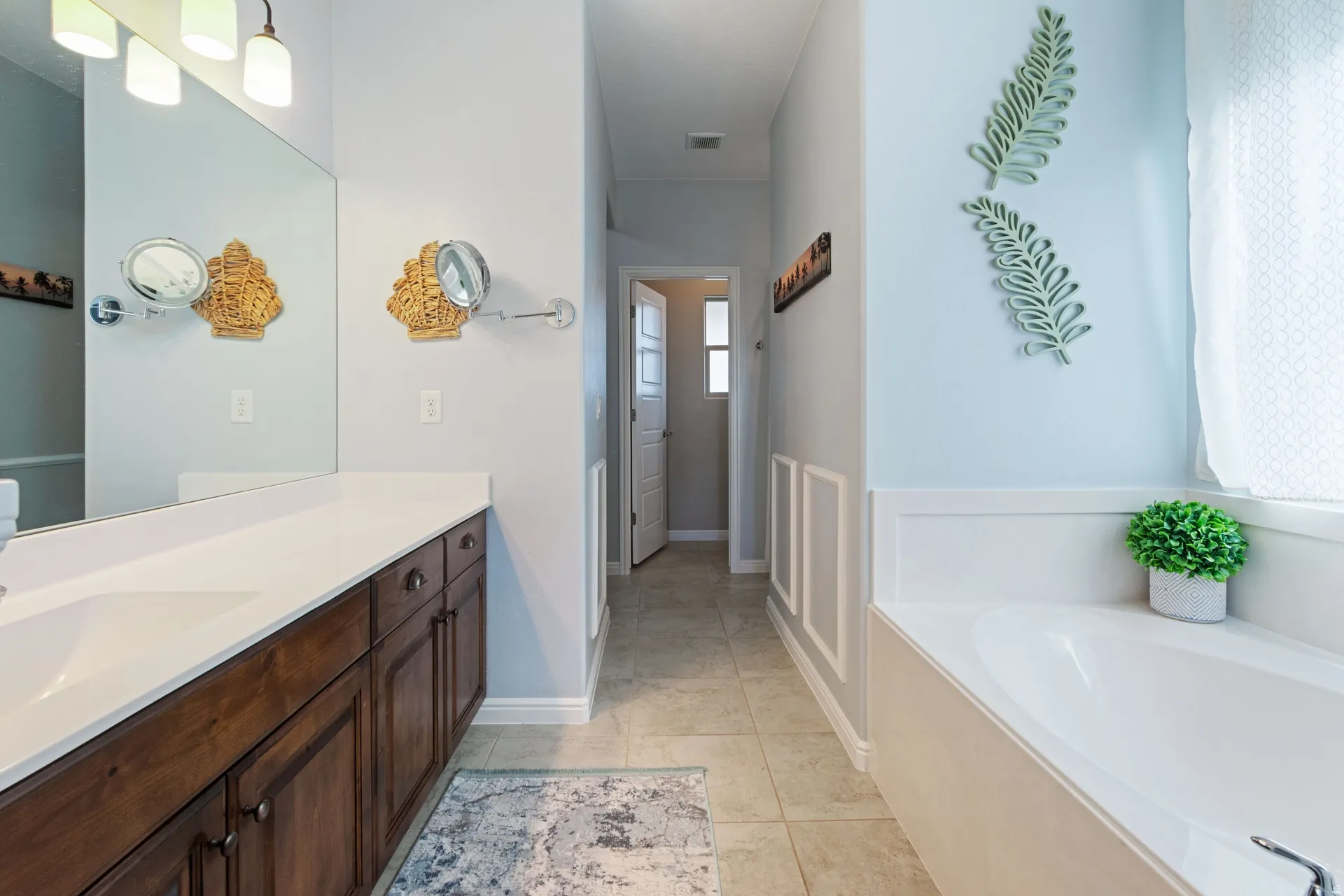 Bathroom with vanity, a garden tub, and light tile patterned floors