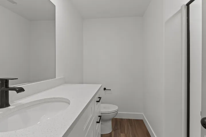 Half bathroom with vanity and dark wood-style floors