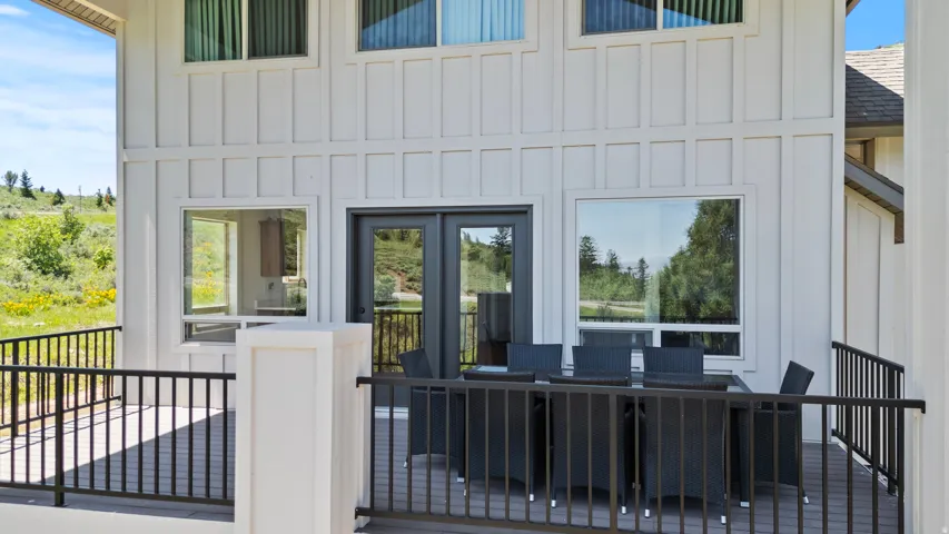Doorway to property featuring board and batten siding, a shingled roof, and outdoor dining space