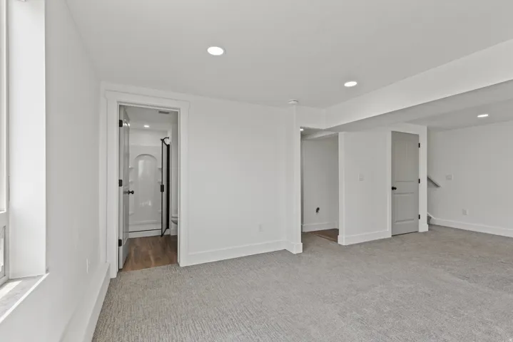 Unfurnished bedroom featuring light carpet, recessed lighting, and ensuite bath