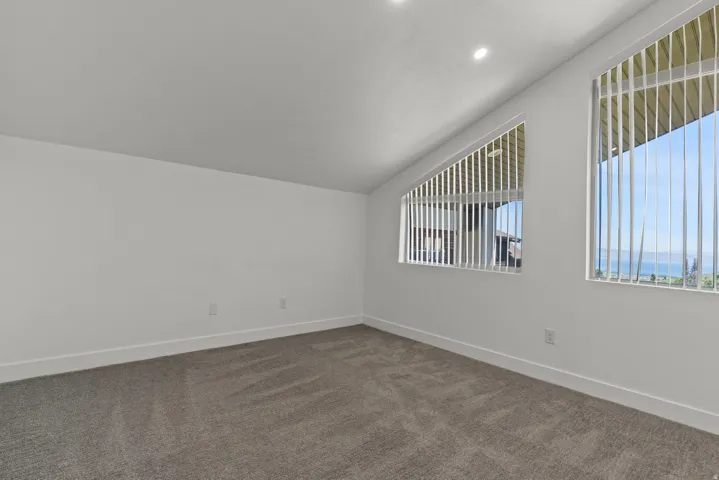 Bonus room with vaulted ceiling and dark carpet