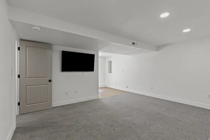 Unfurnished room featuring light carpet, recessed lighting, and a smoke detector