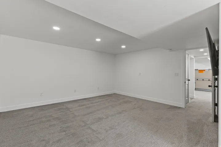 Empty room featuring light colored carpet and recessed lighting