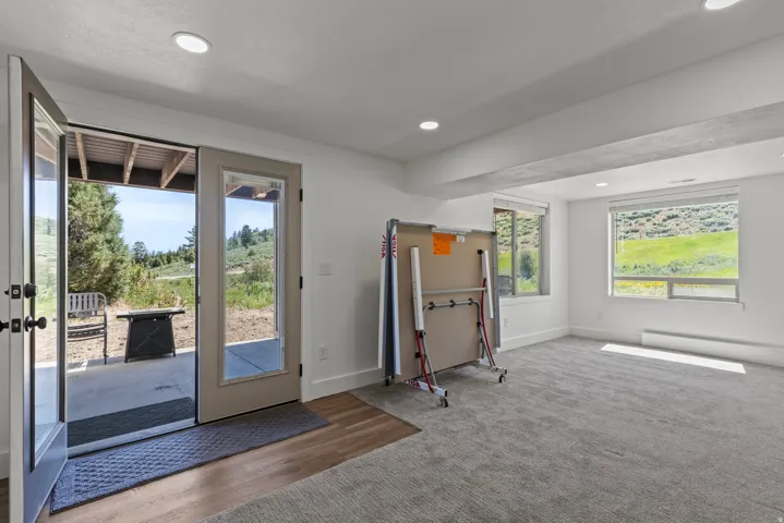 Doorway featuring recessed lighting, carpet floors, baseboard heating, and wood finished floors