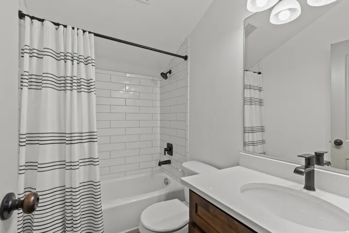 Full bath featuring vanity and shower / bath combination with curtain
