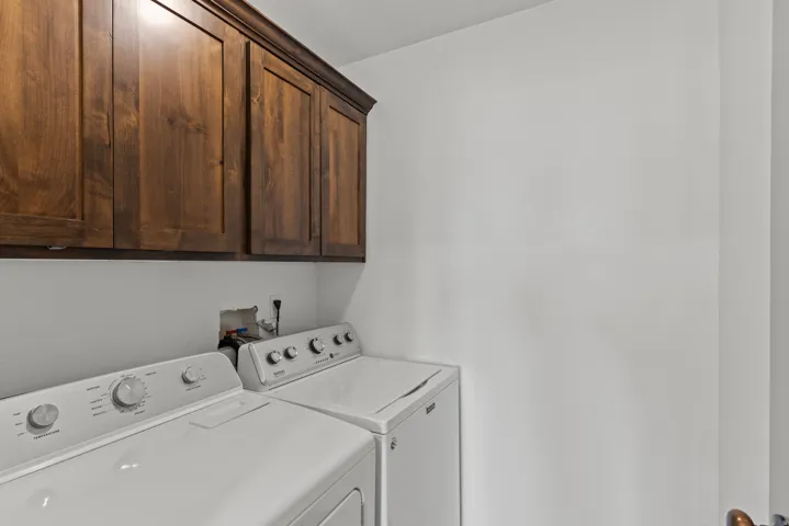 Laundry area with cabinet space and washer and clothes dryer