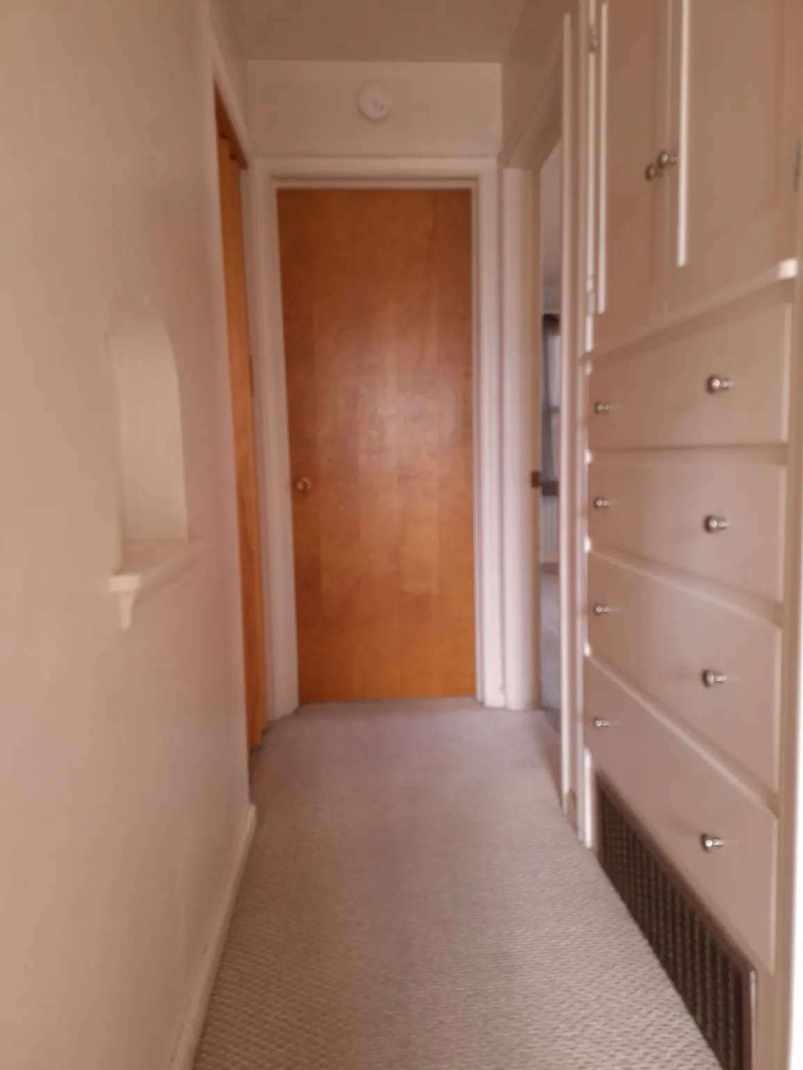 Hallway view from bathroom has built-in storage