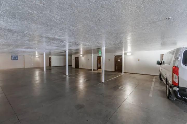 View of parking garage with 2 designated parking spaces as well as an owner storeroom