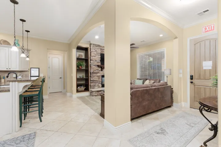 Entrance foyer with arched walkways, crown molding, recessed lighting, and light tile flooring