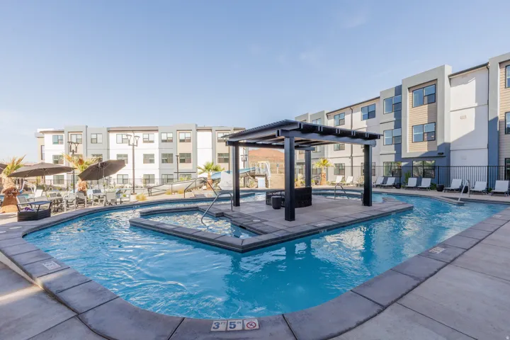 Community pool with a lazy river, pergola and a patio area