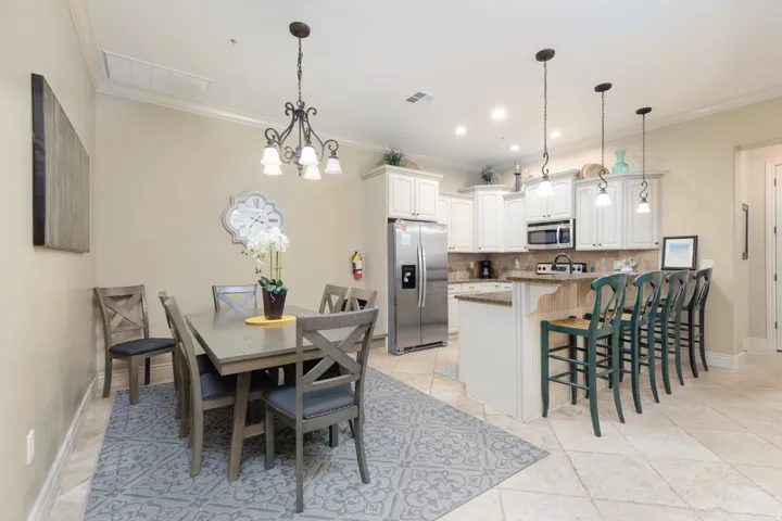 Dining space featuring a chandelier and crown molding and kitchen