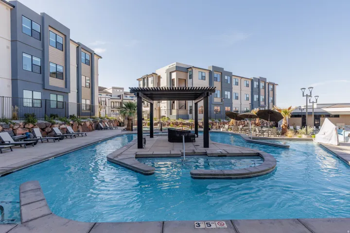 Community pool featuring a pergola and a lazy river and patio area