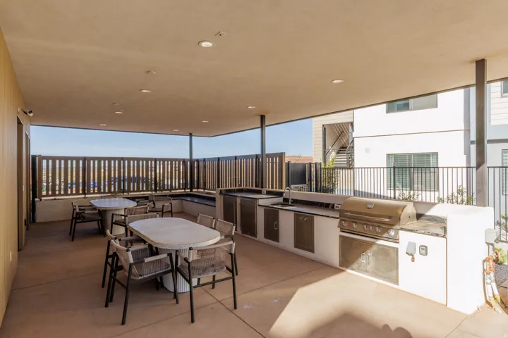 View of patio featuring an outdoor kitchen / dining area and a sink by the community pool