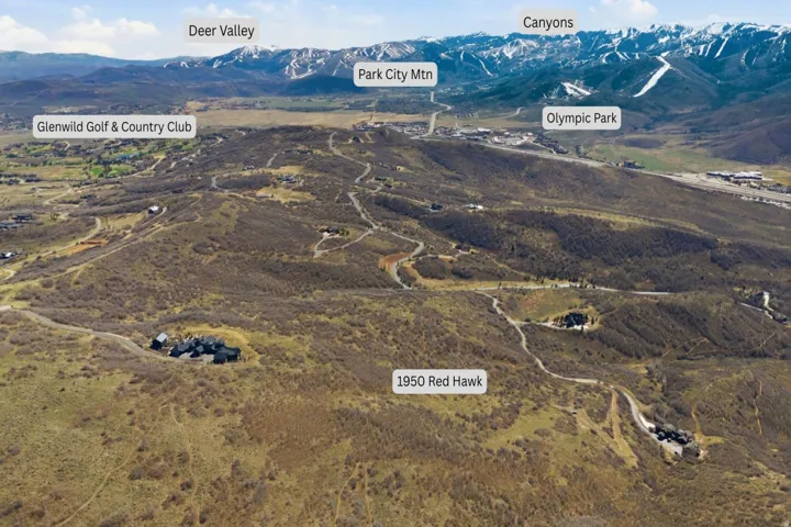 Expansive mountainous terrain featuring a secluded property, surrounding natural landscape, and distant mountain ranges