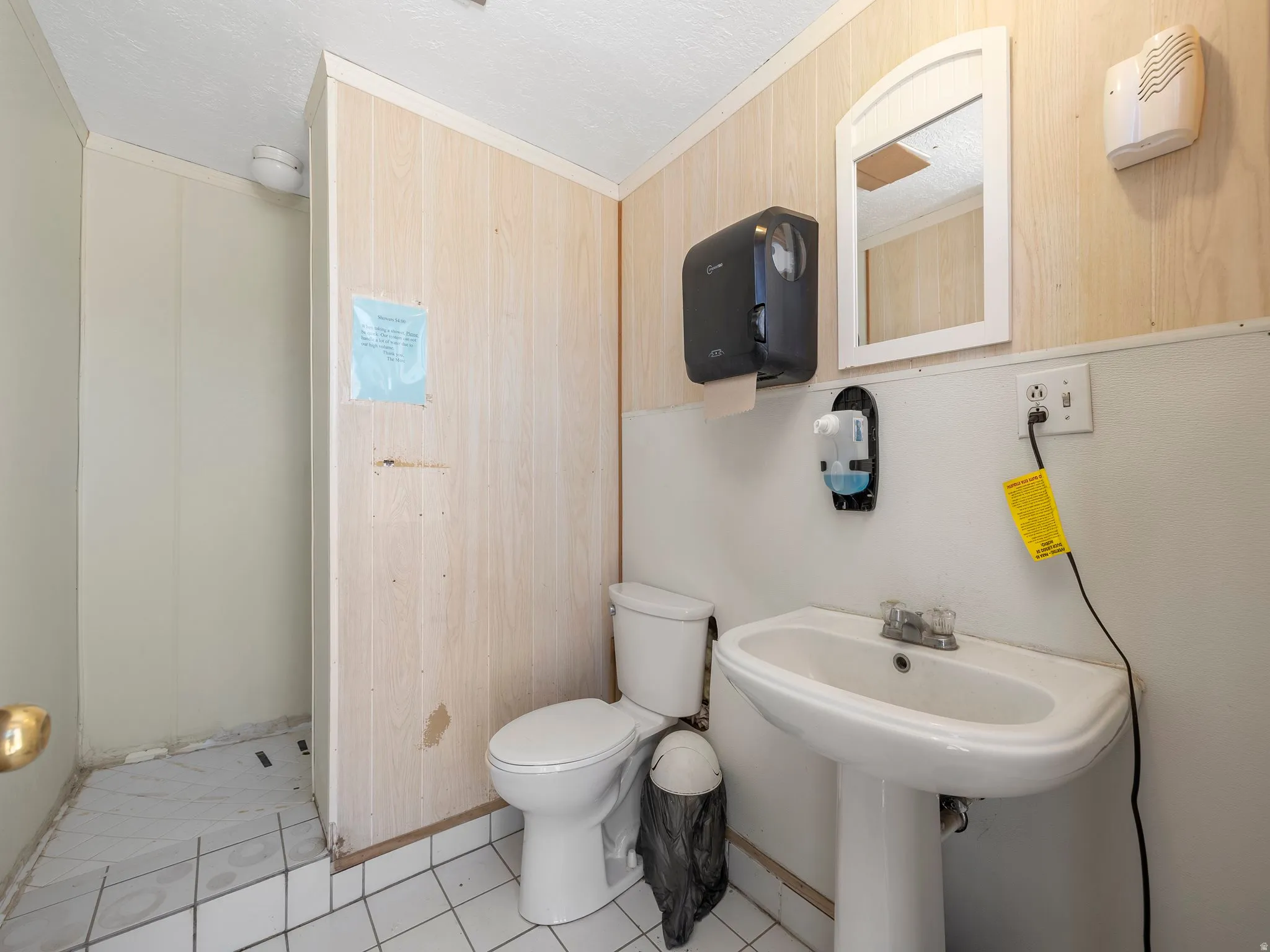 Bathroom featuring ornamental molding, light tile patterned floors, and a textured ceiling