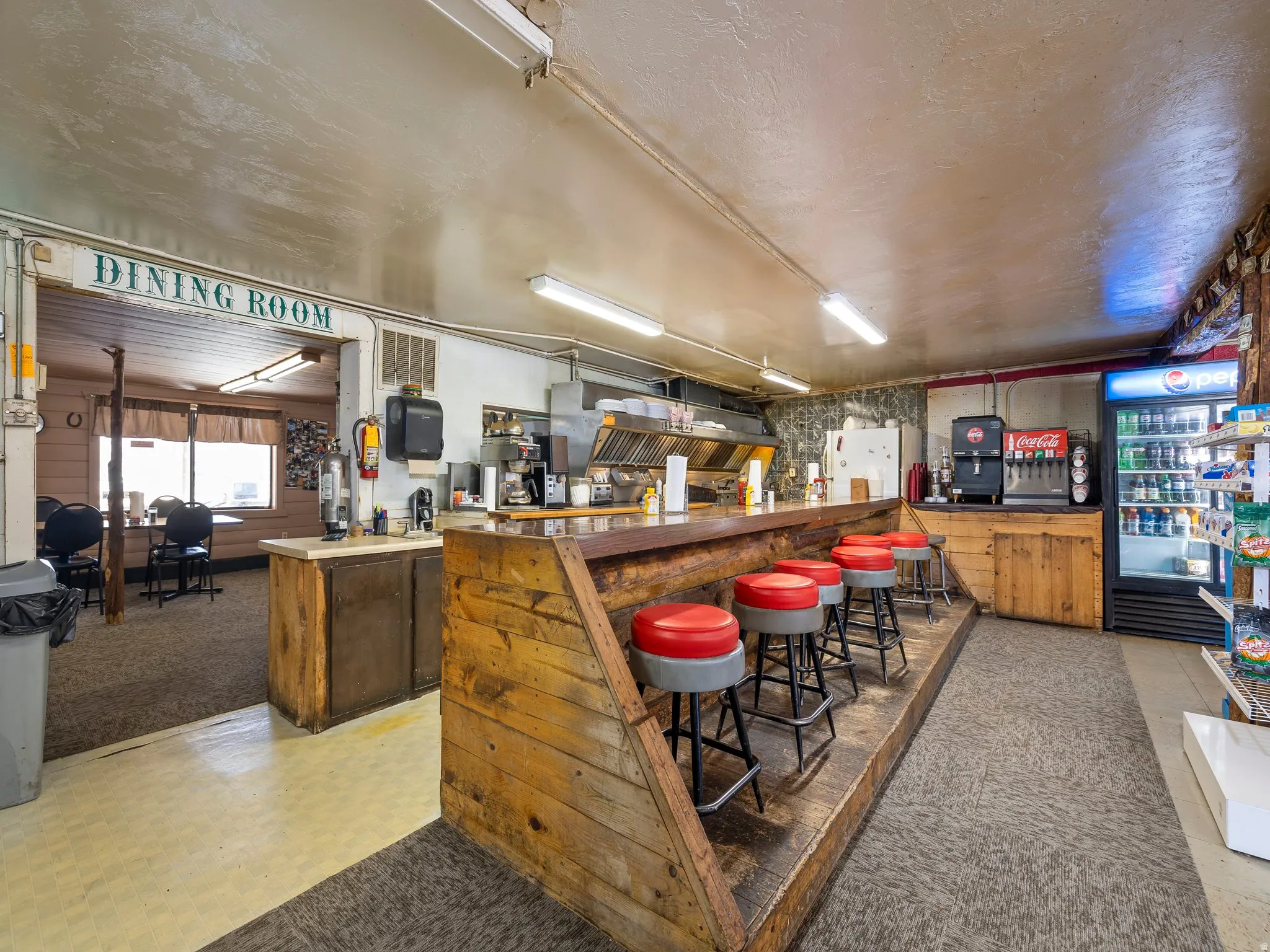 Indoor dry bar with freestanding refrigerator and wood finish cabinets