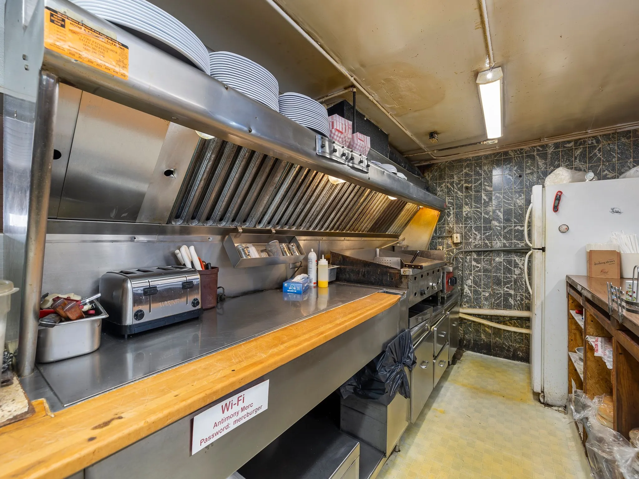 Kitchen with extractor fan, freestanding refrigerator, and butcher block counters