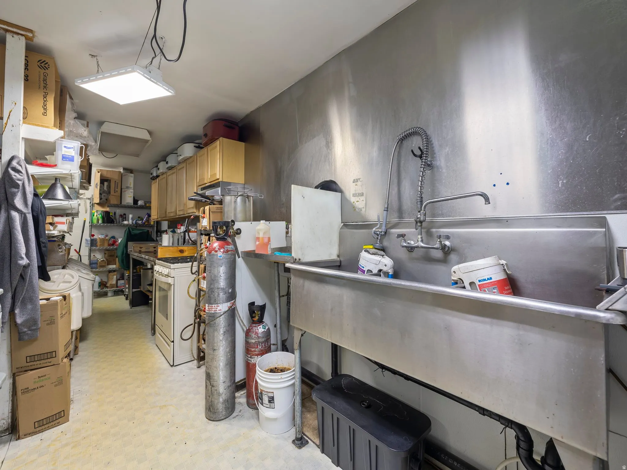 Kitchen featuring light flooring, washer / clothes dryer, and light wood finish cabinetry
