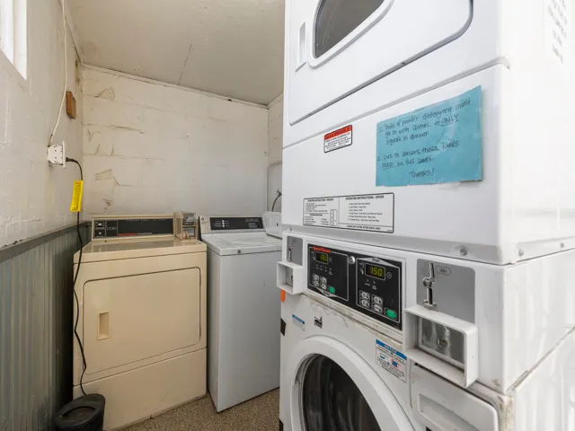 Community laundry room featuring stacked washer / drying machine