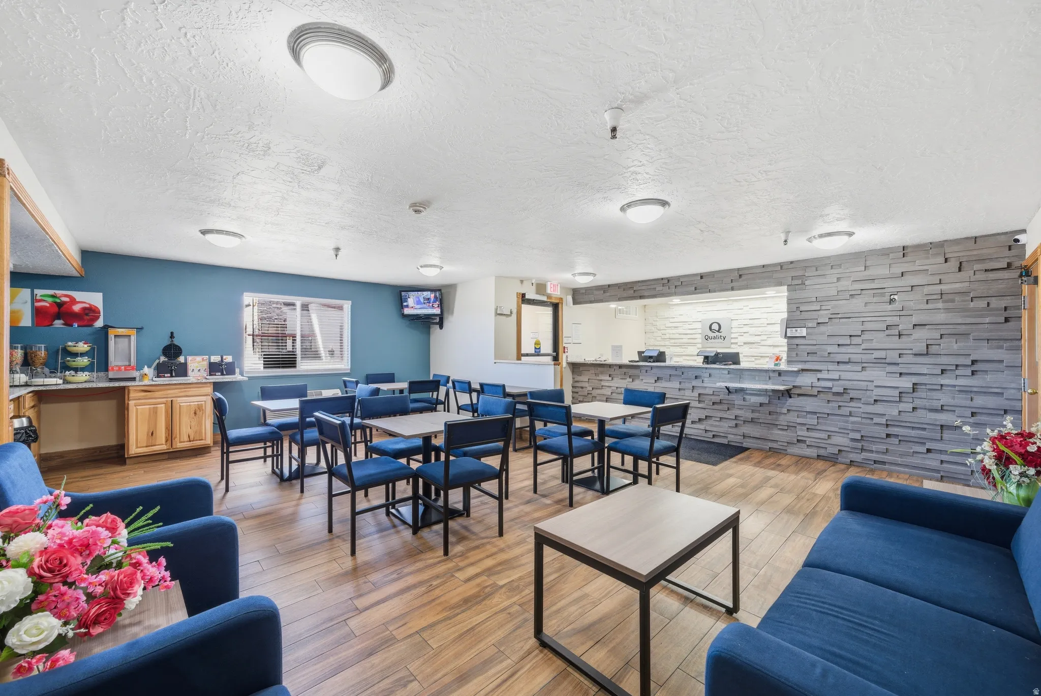 Living room featuring light wood-type flooring, wood walls, a textured ceiling, and an accent wall