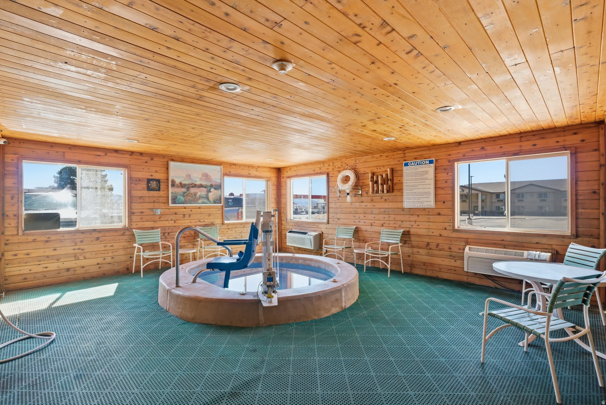 Living room with wooden walls, wood ceiling, and carpet