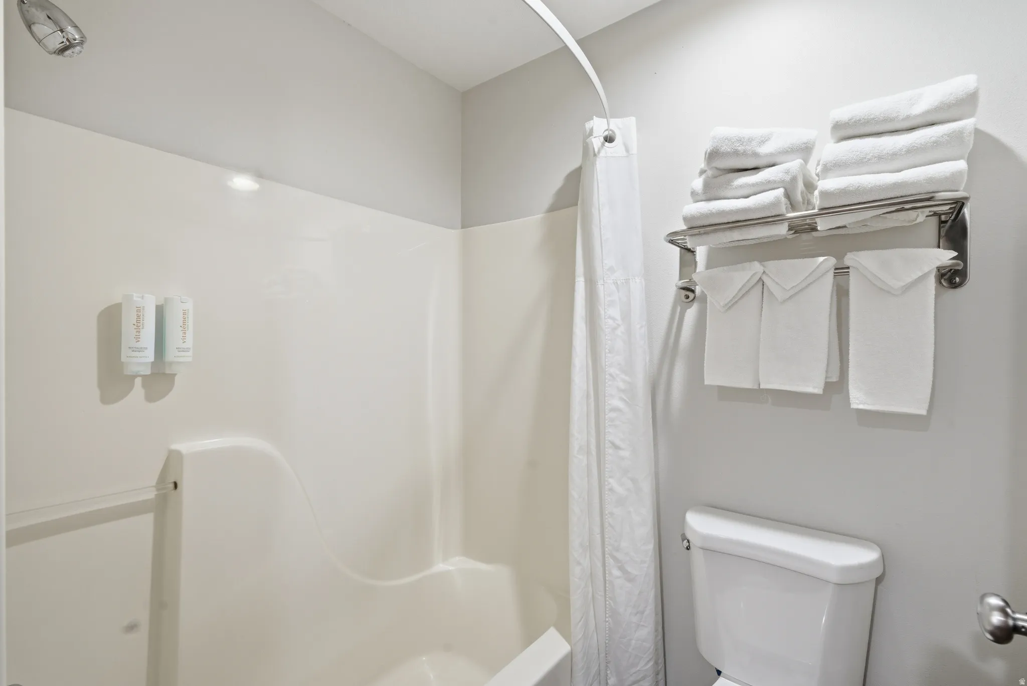 Full bathroom featuring toilet and shower / tub combo with curtain