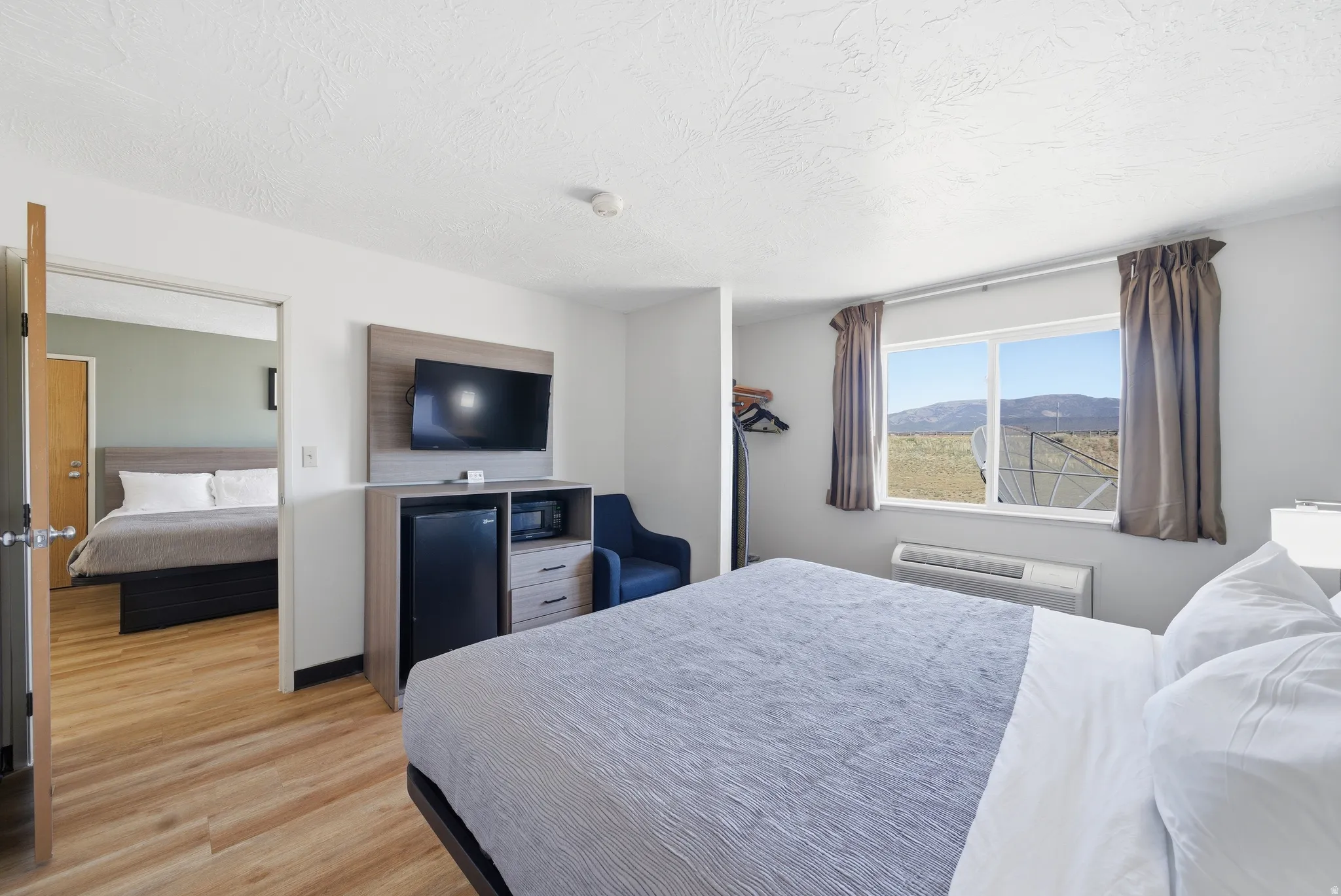 Bedroom with light wood-style flooring and a packaged terminal hvac unit