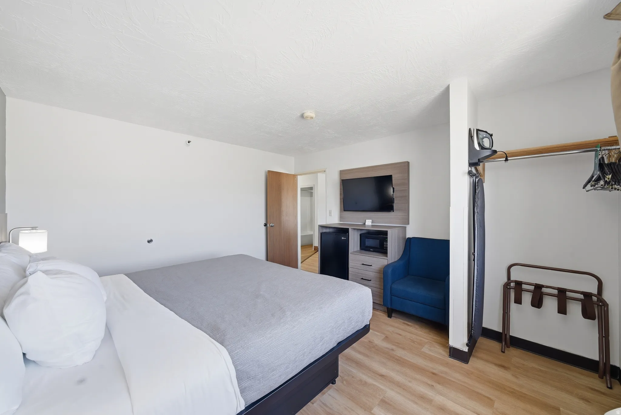 Bedroom featuring light wood-style flooring and black refrigerator