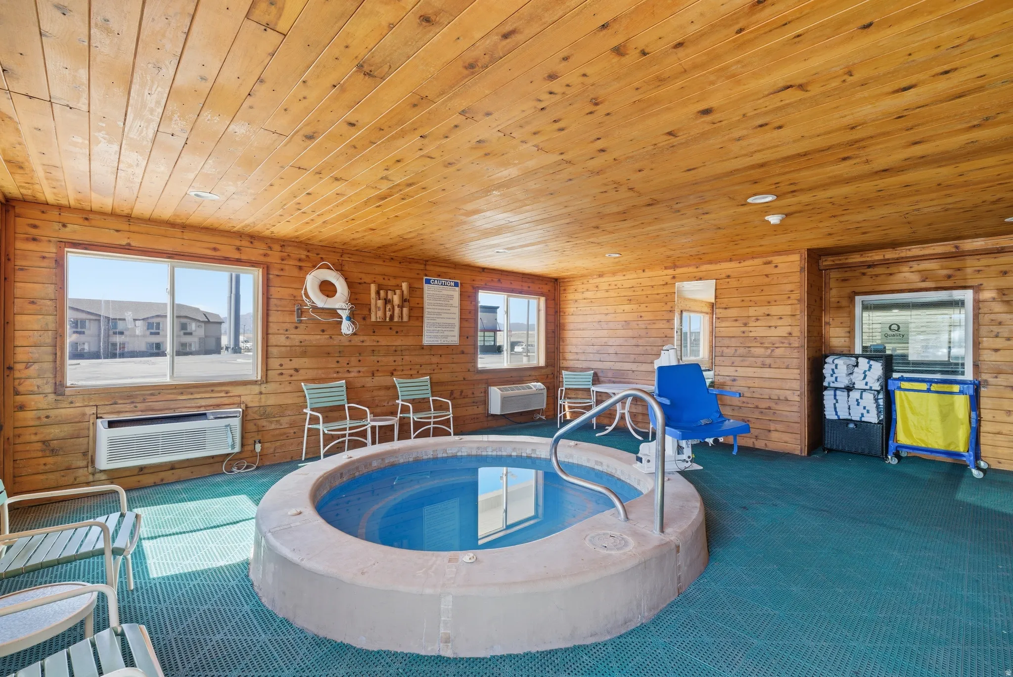 View of pool featuring a hot tub and a wall mounted AC