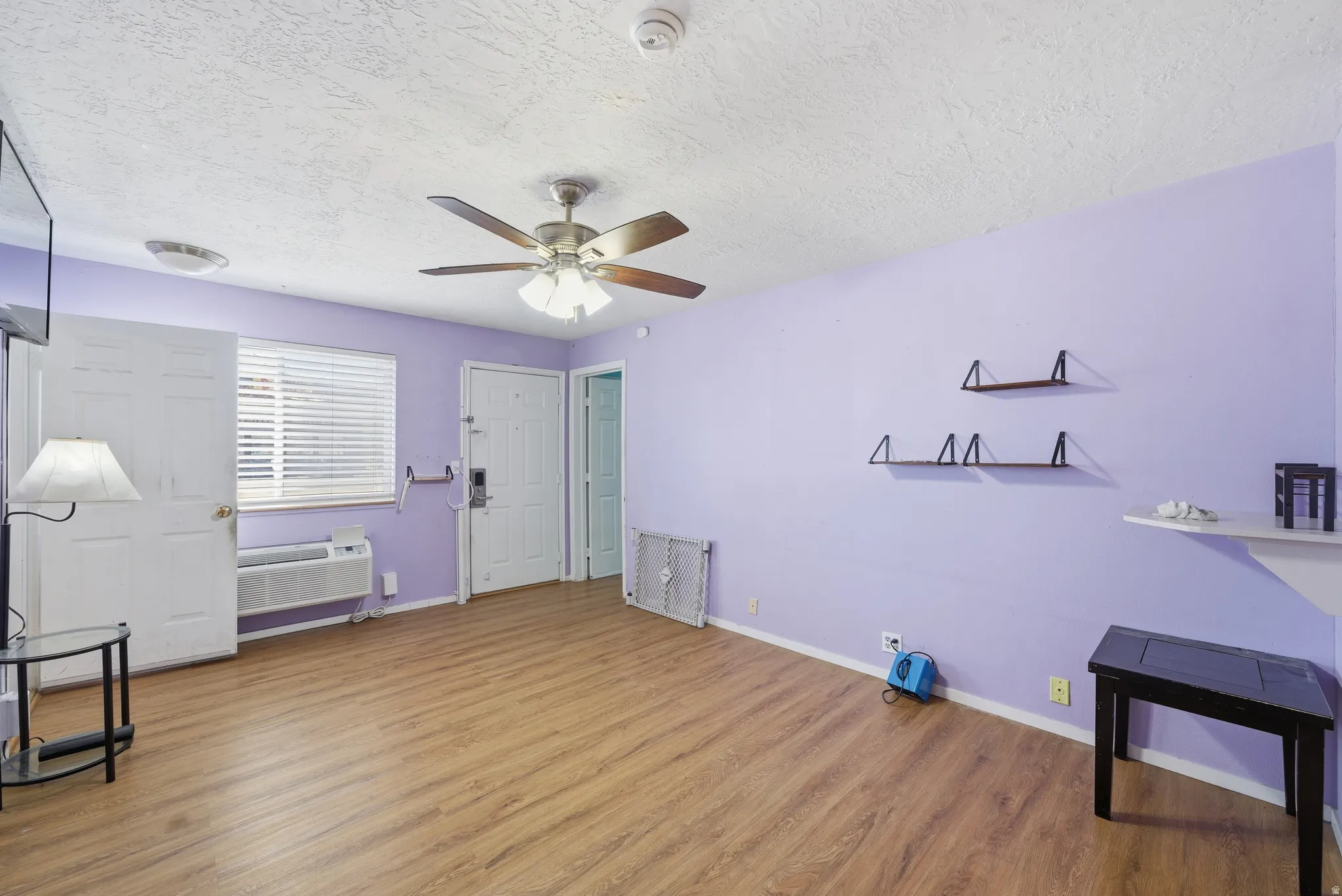 Unfurnished bedroom featuring wood finished floors, a ceiling fan, and a textured ceiling