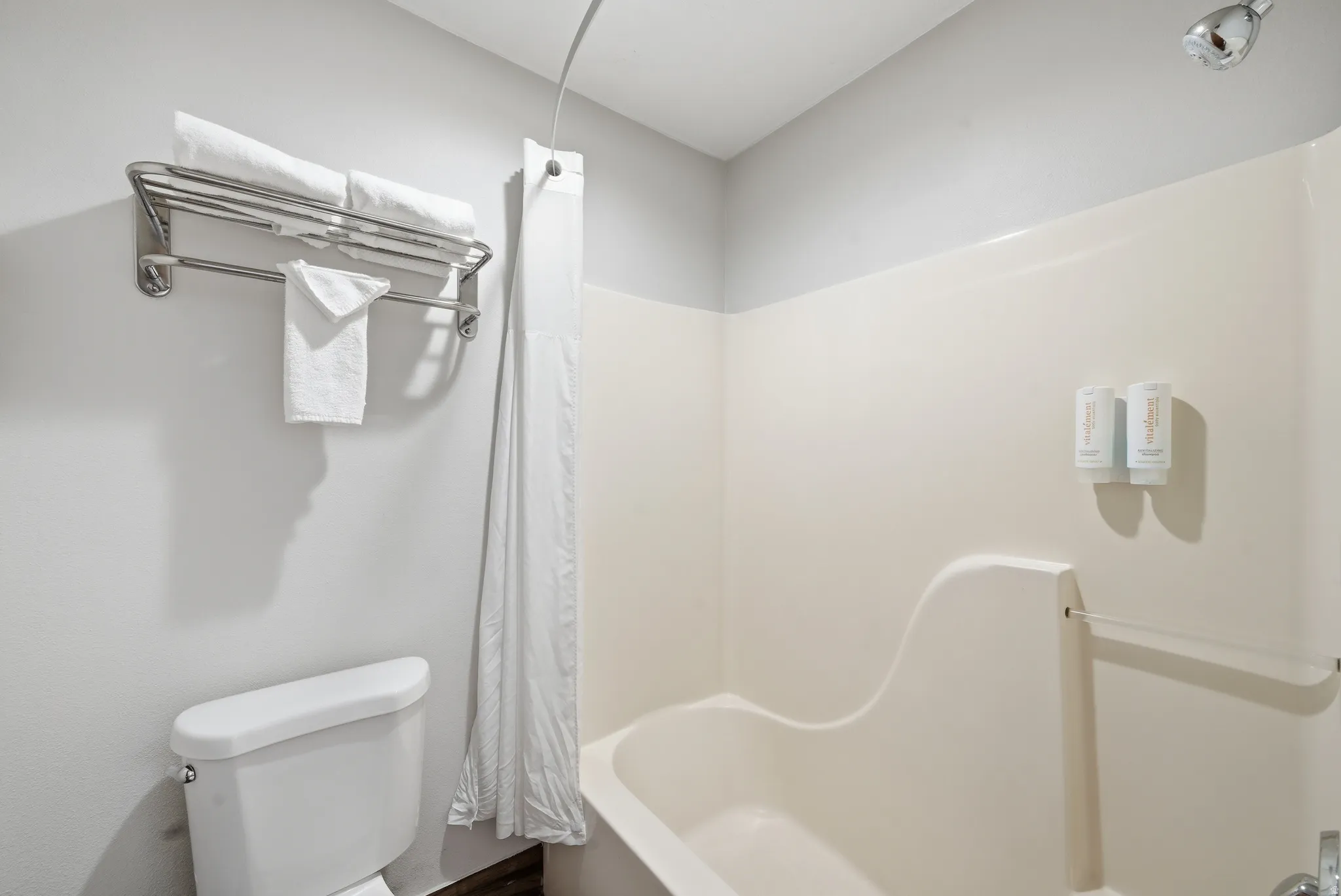 Bathroom with toilet and shower / bath combination with curtain
