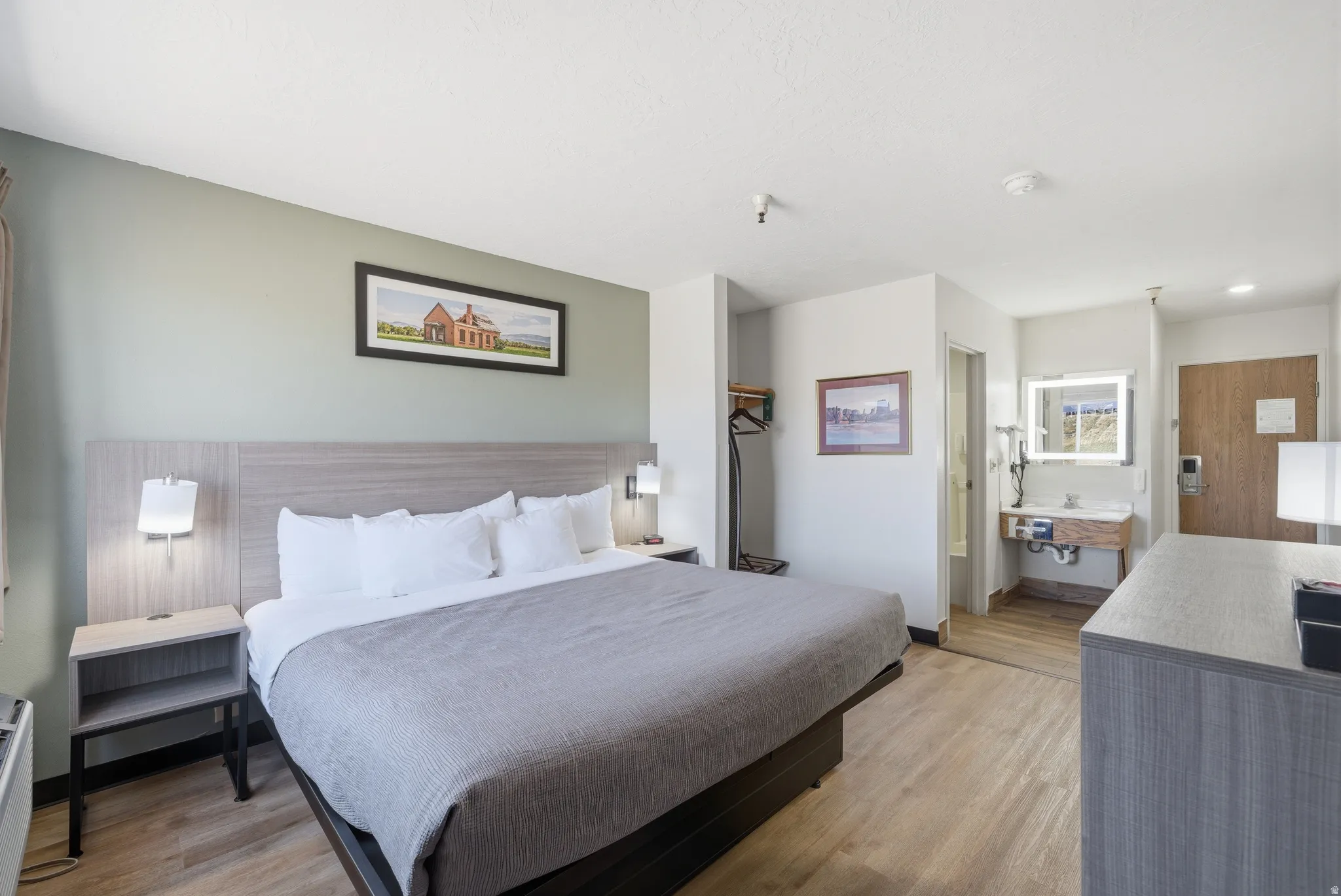 Bedroom with light wood-style flooring and ensuite bathroom
